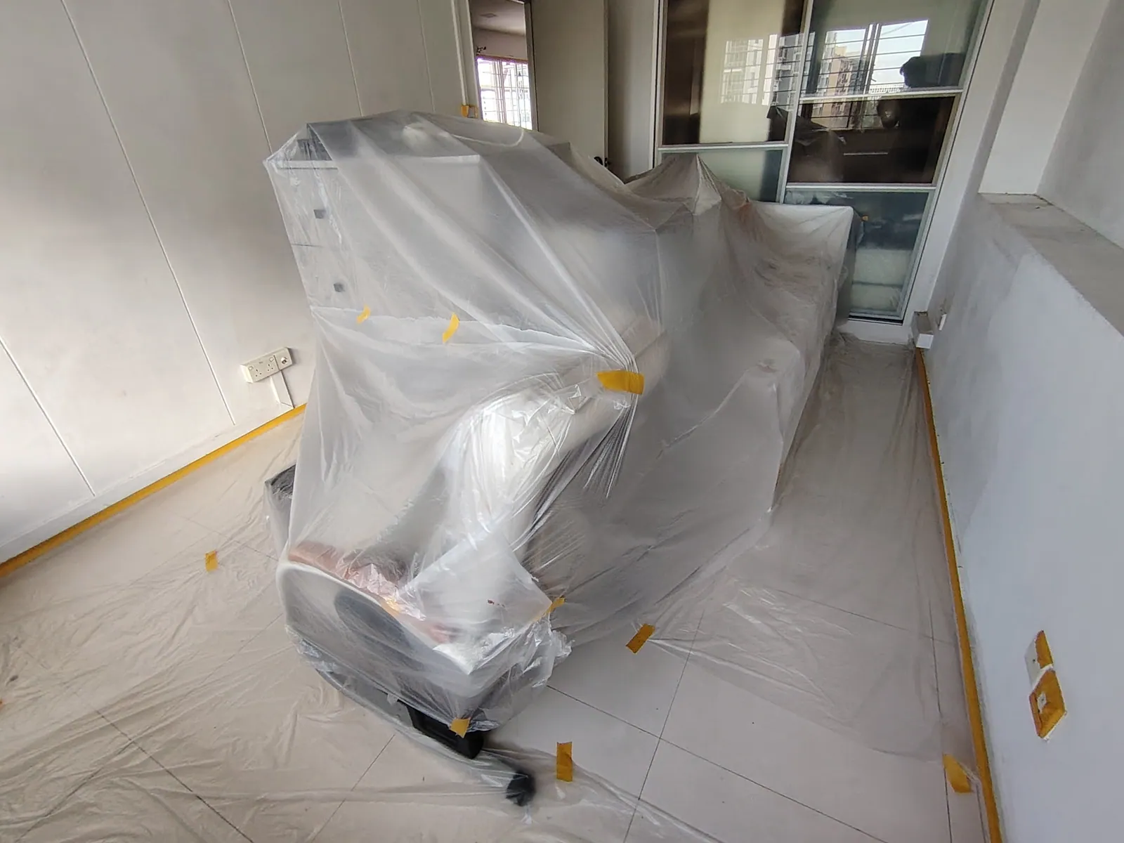 Furniture wrapped before painting begins.